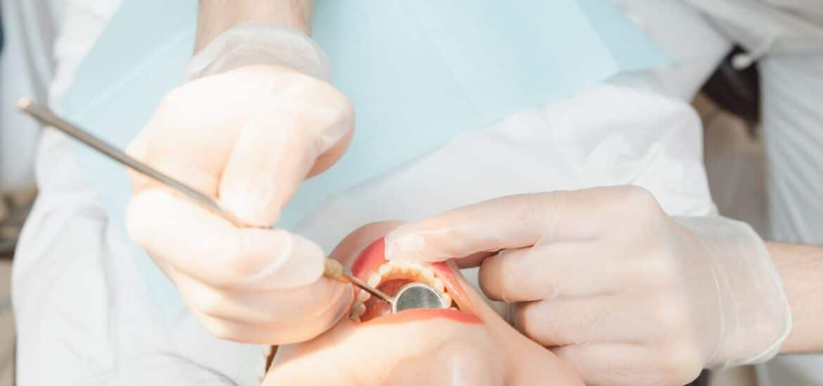A dentist examining a patient’s teeth during a cosmetic dentistry procedure.