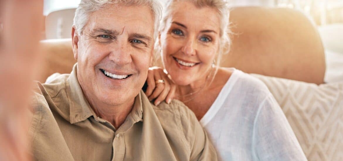 Senior couple smiling together after a dental checkup.