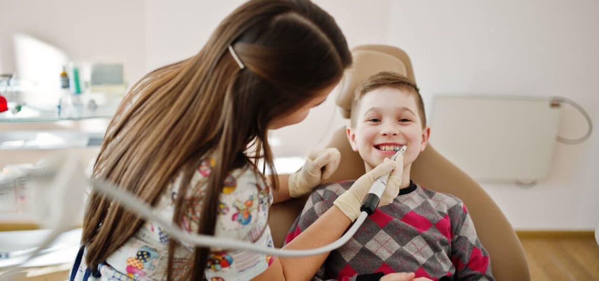 A child smiling during a dental checkup with a family dentist.
