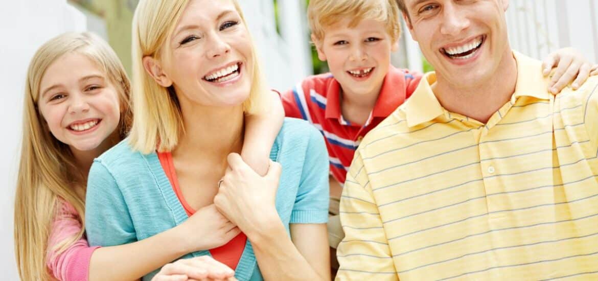 Smiling family sitting together in a bright, calm setting that reflects comfort, trust, and a stress-free dental care experience.