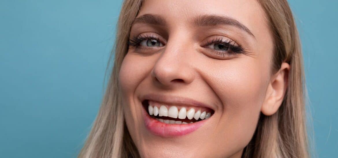 Smiling woman with healthy restored teeth after cosmetic dentistry treatment for an injured smile.