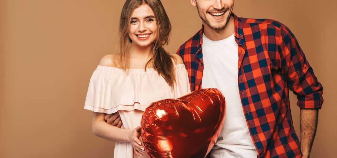 Couple smiling confidently on Valentine’s Day after cosmetic dental care.